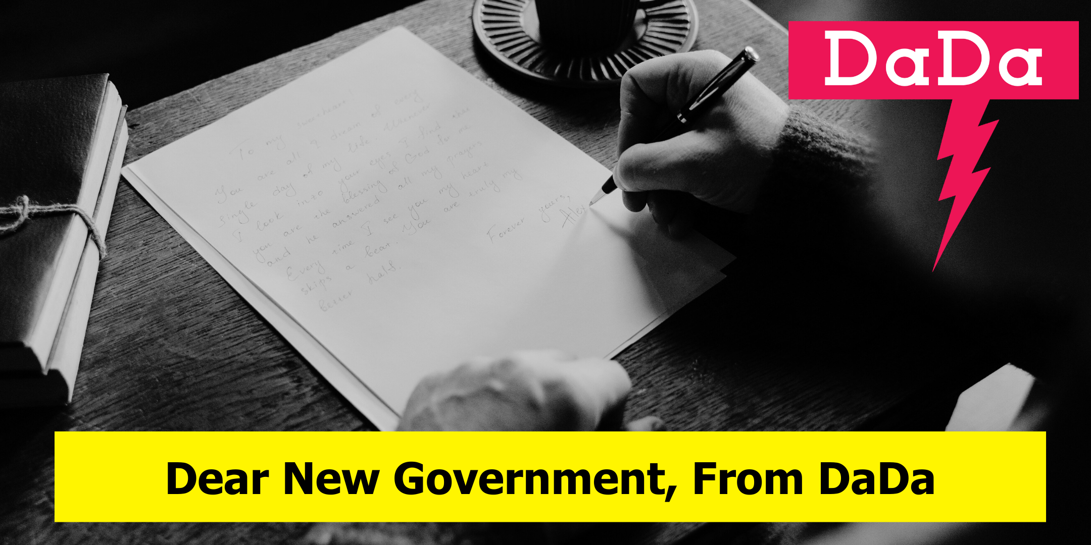 Someone leans over a desk with a pan in hand writing a letter. Words overlaid 'Dear New Government, An open letter from DaDa'